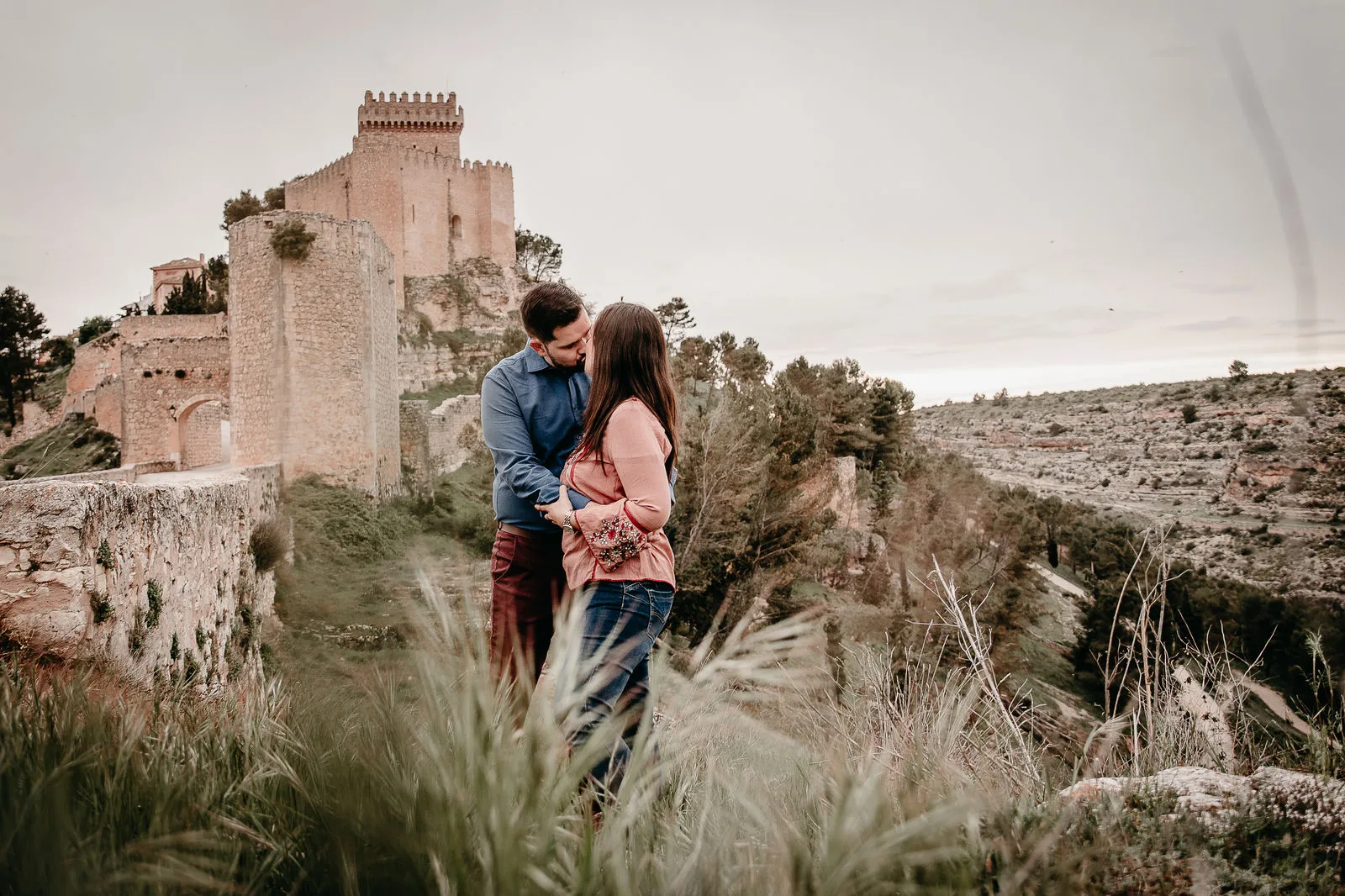 Pareja abrazada ante un castillo