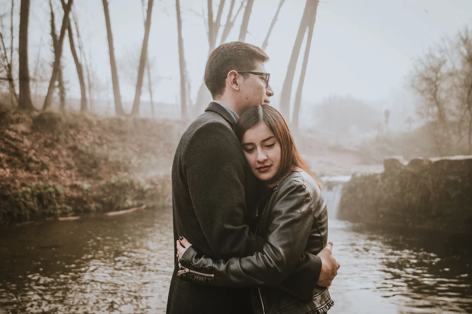 Pareja abrazada junto a un río