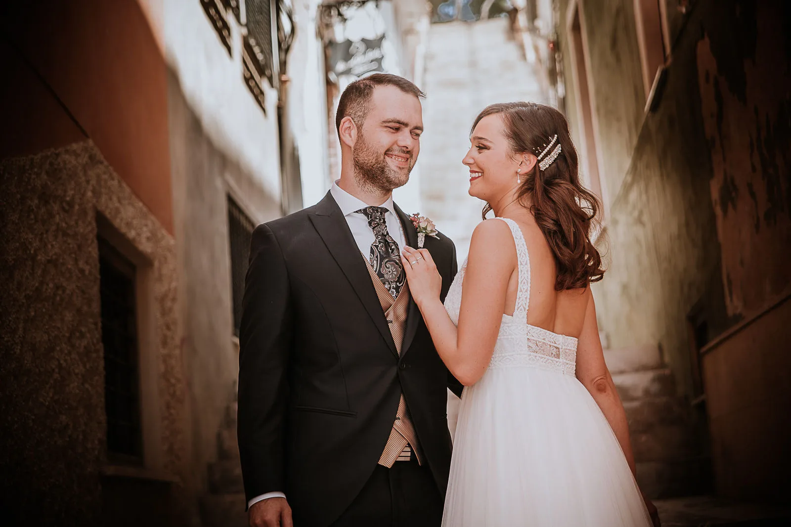 Pareja sonriendo en una calle de piedra