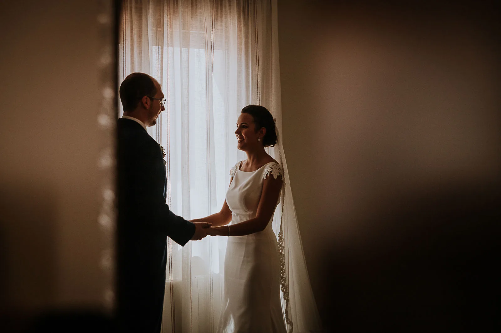 Novia junto a una ventana durante los preparativos