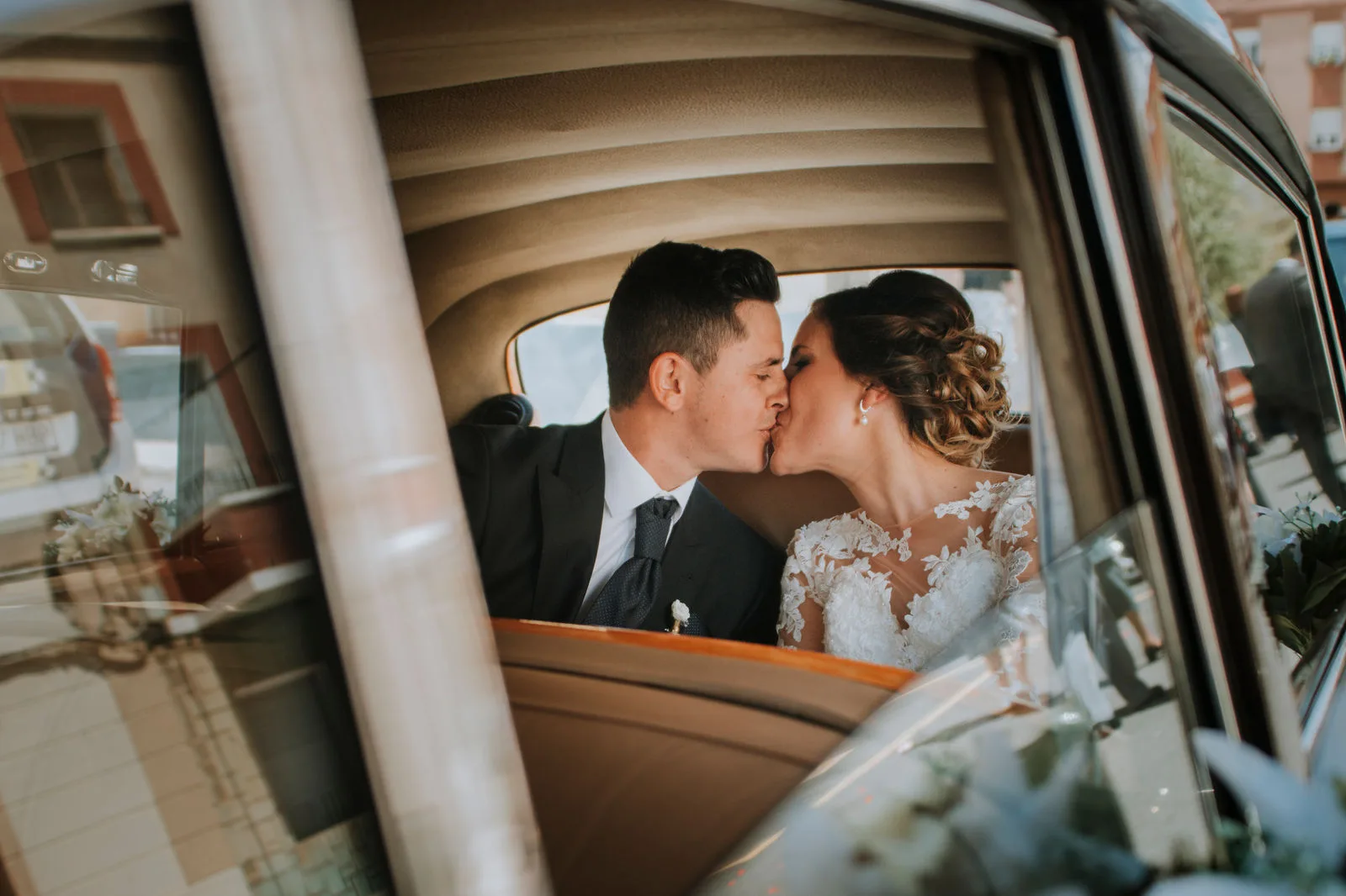 Pareja besándose en el interior de un coche clásico