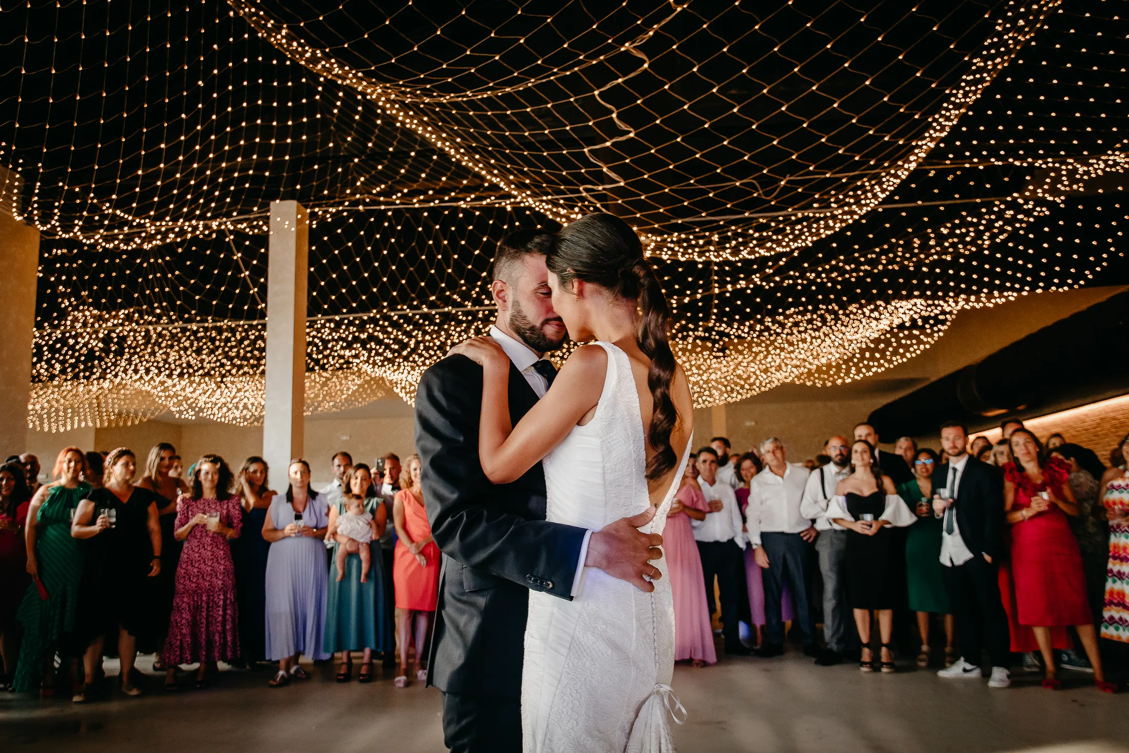 Una pareja baila de noche bajo un cielo de luces
